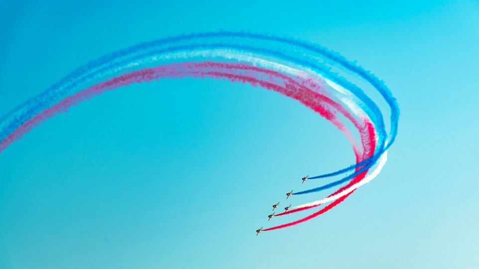 a group of red, white and blue airplanes flying in formation